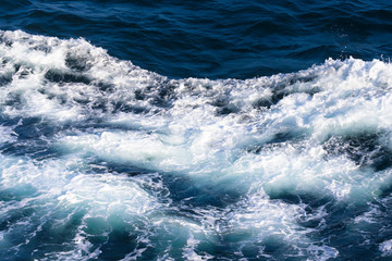 Fototapeta na wymiar White crest of a sea wave. Selective focus. Shallow depth of field