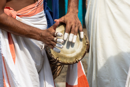 A person playing an instrument called Timila which is made of polished jackwood and held together by leather brazes. It is one of the five musical instrument in Panchavadyam .