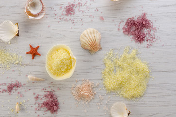 Sea shells and colored aroma bath salts on white wooden background, Spa and body care