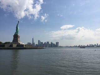 New York City Manhattan skyline from the sea with the liberty statue in a sunny day