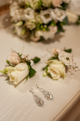 Earrings and two flower buds on the table