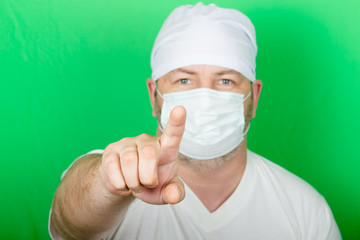 Male doctor in a protective mask on his face points a finger at you