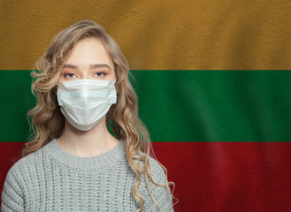 Young woman wearing a face mask with Lithuanian  flag. Flu epidemic and virus protection concept
