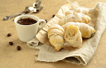 Breakfast with coffee and croissant  sprinkled with powdered sugar