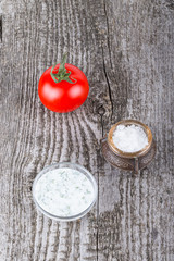 Tomato, dill souse and salt in old metal salt shaker on old wooden table for background