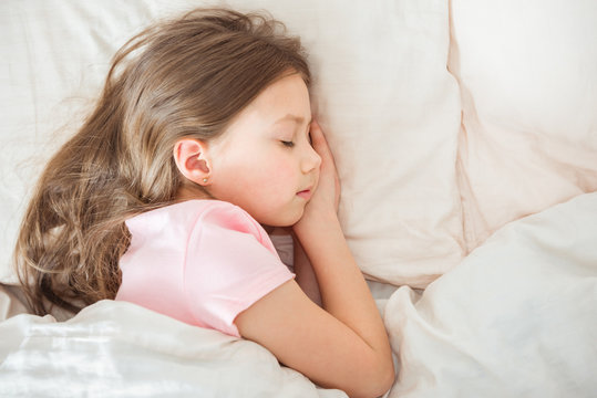 Adorable little girl sleep in the bed close-up