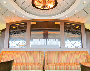 Close up and detail view of coucher with stripes and wooden backwall inside restaurant on...