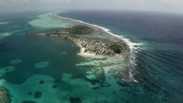 Aerial panning view of island amidst sea against sky - Coco Plum Cay, Belize