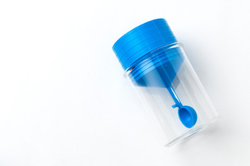 Faecale test container with blue caps and spatula on white background