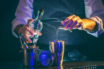 Bartender pouring vodka into cocktail shaker