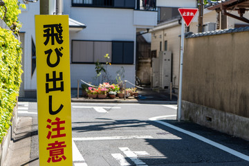 道路の「止まれ」標識と「飛び出し注意」の注意喚起案内板