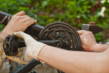 Masters repair the bicycle in white rubber gloves. Tools in hands close up.