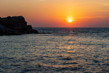 Fototapeta na wymiar Sunrise over the ocean at a small tropical island in the Andaman Sea