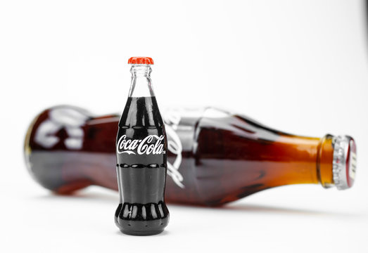Atlanta GA USA May 1 2020 toy glass Coca-Cola contour bottles Vintage shape isolated on white background close up big and small concept concept of global brand Coca-Cola from USA