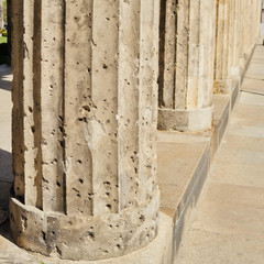 Bullet ridden ancient neo classical greek column scarred with many impacts, reminding signs of the Wold War II in Berlin.