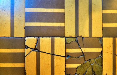 Old ceramic tiles with linear patterns and cracks for wall and floor decoration. Concrete stone surface background.
