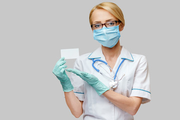 Doctor or woman nurse showing blank empty card with copy space
