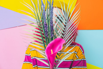 Woman holds tropical bouquet with lily flower and palm leaves. Concept of summer holidays and...