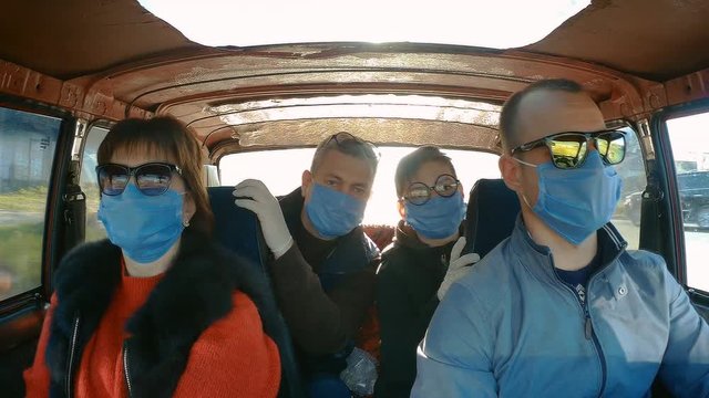 Action camera shot from inside a moving old car: a family in protective masks during an epidemic. coronavirus
