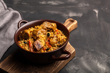 Large portion of pilaf in a clay dish. Delicious uzbek homemade meal