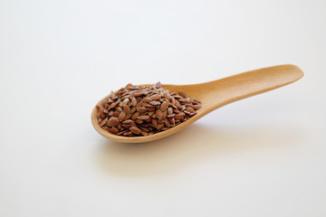 Brown Flax seeds or Linseeds or Common flax in the wooden spoon isolated on white background. 