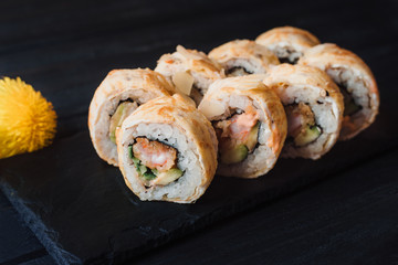 Japanese cuisine. Japanese sushi with soy sauce and wasabi on black stone plate on black background.