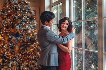 Couple in love for New Year or Christmas in elegant clothes together on the background of the...