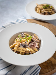 Garlic Mushroom Pasta served in a white bowl on wooden background