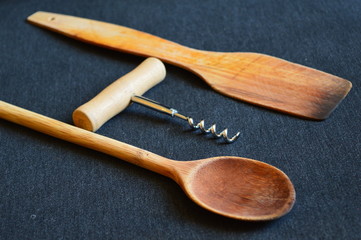 wooden spoons and corkscrew for wine  on a black board