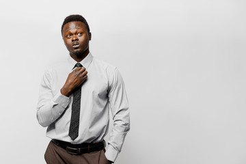 Grimacing handsome black man in white shirt and black tie on white background. Stay at home and do on-line work