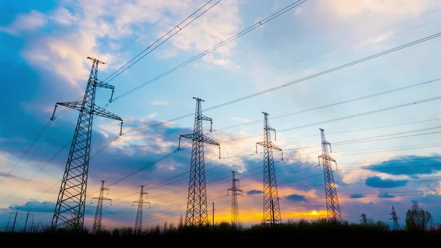 Time Lapse of Electrical Grid and Transmission Line at Sunset. Electricity Pylons Against Sky During Sunset. Clouds Moving Across Sky. Landscape of High Voltage Towers. 4K UHD ProRes 422 (HQ)
