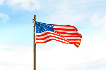 USA flag on flagpole on sky background.