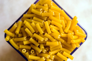 raw italian macaroni pasta inside clear storage container