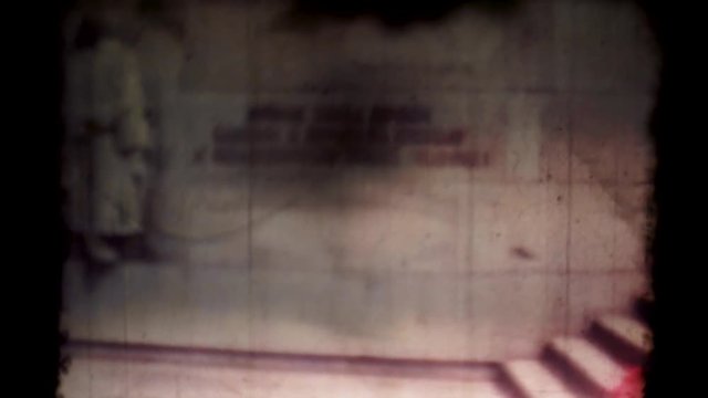 Old projector shows a movie with an old Prague 60s. Group of people on excursions