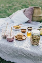Beautiful cozy summer or spring picnic with cocoa, pancakes, honey, strawberries, pears and granola.