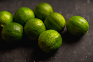 Juicy green limes on the rustic background. Selective focus. Shallow depth of field.
