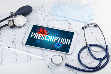 Tablet pc and doctor tools on white surface with PRESCRIPTION inscription, pandemic concept