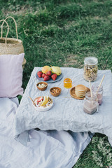 Beautiful cozy summer or spring picnic with cocoa, pancakes, honey, strawberries, pears and granola.
