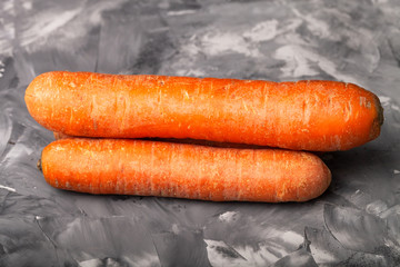 Composition with a carrot on a textured plastered surface