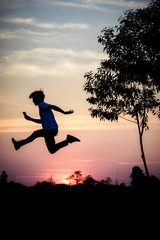 Freedom-young man is jumping at lake with sunset sky