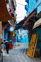 Calle tipica de Chaouen en Marruecos con sus comercios y colores característicos.
