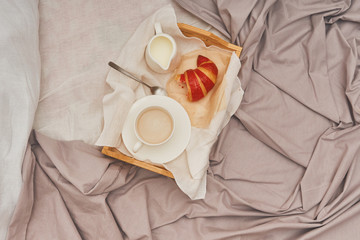 Breakfast in bed, coffee with cream, croissants in jam