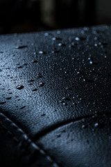 Dark leather texture with rain drops on vertical composition