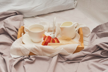 Fototapeta na wymiar Breakfast in bed, coffee with cream, croissants in jam