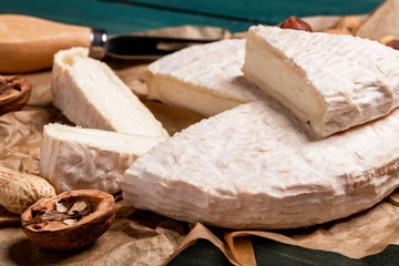 Italian food. Camembert and brie cheese on wooden background with nuts. Dairy products. close up view