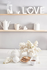 Fototapeta na wymiar Tea set, cookies and white lilac on kitchen table. Happy birthday greeting card. Hello spring and summer. Greeting card for Women's Day and Mother's Day. Spring season, copy space.Romantic breakfast