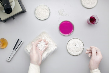 Laboratory assistant in protective gloves conducts an experiment.