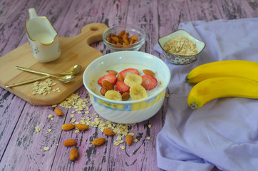 Healthy oatmeal porridge with milk decorated with pieces of fruit and berries top view