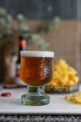 Closeup view of a cold frozen foamy beer mug on a marble table.