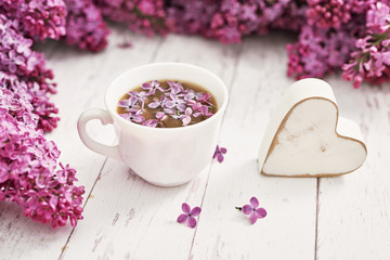 Good morning concept. Cozy morning.Happy birthday greeting card. Hello spring and summer. Greeting card for Women's Day and Mother's Day. Spring season, copy space. Cup and lilac flowers.
